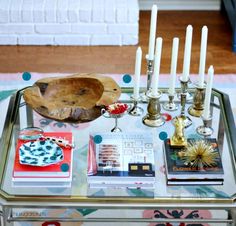 a glass table topped with candles and books