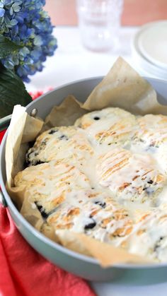 a pan filled with food sitting on top of a table next to a blue flower