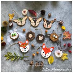 some ornaments are laying on the ground with leaves and flowers around them, including pine cones