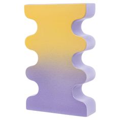 a purple and yellow vase sitting on top of a white table