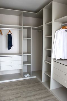 an empty walk in closet with white cabinets and drawers