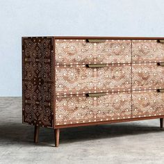 a brown and white dresser sitting on top of a cement floor