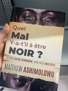 a person holding up a book in front of their face with the title'quel mai ya - atti la ete noir? noir?? '