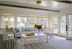 a living room filled with furniture and lots of windows