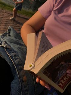 a person sitting on the ground reading a book