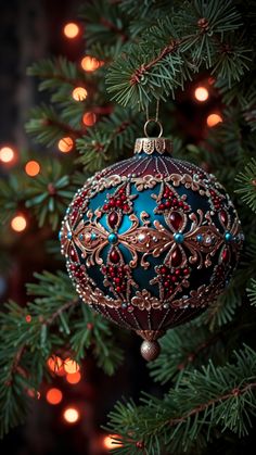 a christmas ornament hanging on a tree with lights in the background and an evergreen branch