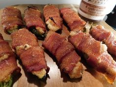 bacon wrapped hot dogs on a wooden cutting board