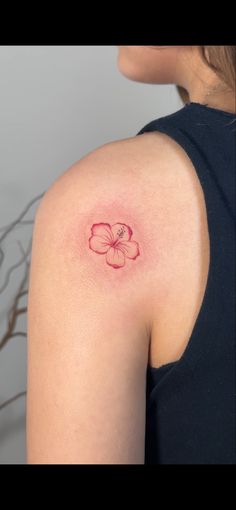 a woman with a small flower tattoo on her shoulder