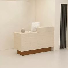 a white reception table with a vase on it in an empty room next to a window