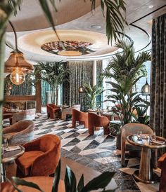 the interior of a fancy restaurant with potted plants and checkered tile flooring