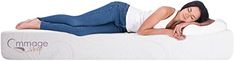 a woman laying on top of a white mattress