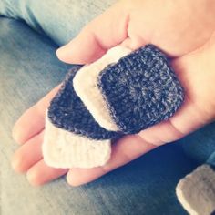 a person holding a small knitted object in their hand