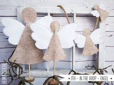 paper angel decorations are hanging on a wooden frame with twine and twine around them