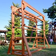 a wooden swing set sitting on top of a lush green field