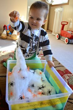 a young boy is playing with fake spider webs