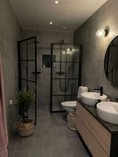 a bathroom with two sinks, a toilet and a shower stall in it's corner