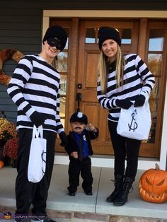 two people in costumes standing on the front porch with a small child dressed up as a jailman