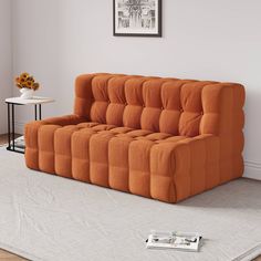 an orange couch sitting on top of a white rug