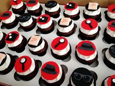 a box filled with lots of cupcakes covered in red and black frosting