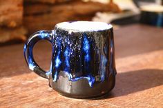 a blue and white mug sitting on top of a wooden table