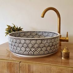 a large bowl sitting on top of a wooden counter next to a faucet