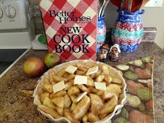 a bowl full of food sitting on top of a counter next to an open book