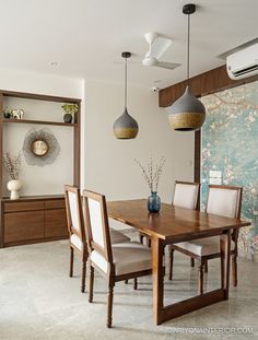 a dining room table with four chairs and a vase on the top shelf in front of it