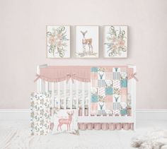 a baby crib with two deer pictures on the wall next to it and a rug