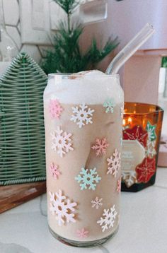 a glass filled with liquid sitting on top of a counter next to a christmas tree