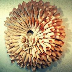 a circular wooden decoration made out of old book pages