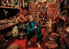 a person sitting in a room filled with lots of items