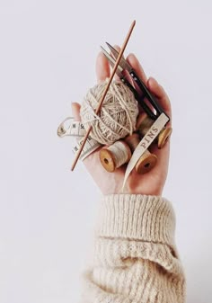 a person holding yarn and knitting needles in their hands