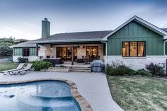 a house with a pool in front of it and a patio area next to it