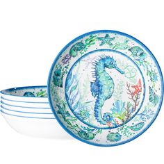 four blue and white plates with seahorses on the front, one in the middle