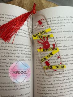 an open book with red tassels and some yellow stickers attached to it