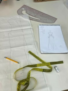 a drawing and measuring tape sit on top of a piece of paper