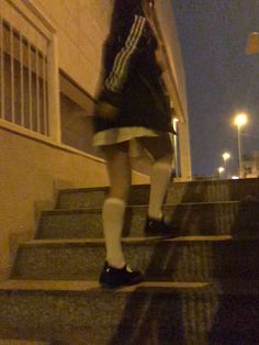 a woman walking up some stairs at night