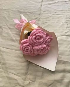 pink crocheted roses on top of a white sheet