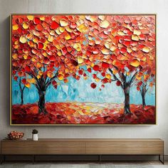 the painting is hanging on the wall in the living room, it looks like an autumn tree