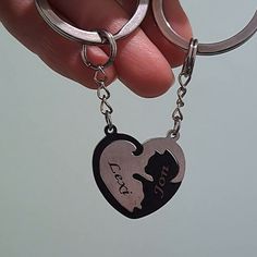 a hand holding a heart shaped key chain