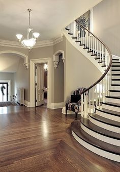 a large foyer with stairs and wooden floors