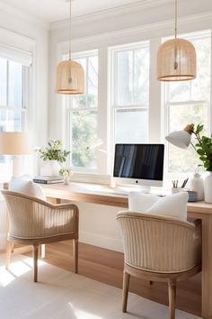 a home office with two chairs and a computer on a desk in front of three windows