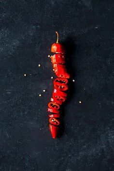 a red pepper sitting on top of a black surface