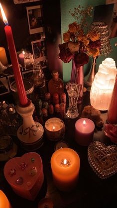 many candles are lit on a table with other items in the room around them,