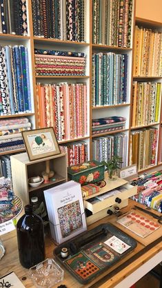 a table topped with lots of different types of fabrics and quilting material on display