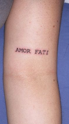 a person with a tattoo on their arm that says, amor fati