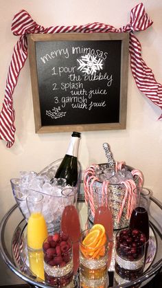 a metal tray topped with drinks next to a chalkboard sign and candy canes