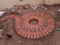 a brick circle in the middle of some dirt