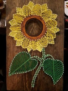 a piece of string art with a sunflower on it