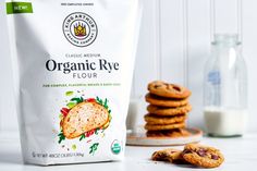 a bag of organic rye flour next to some cookies